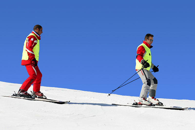 Skieur mal-voyant guidé à la voix par son moniteur Skieur mal-voyant guidé à la voix par son moniteur